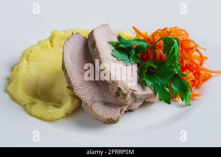 piatto con maiale al forno con purè di patate e carota piccante Foto Stock