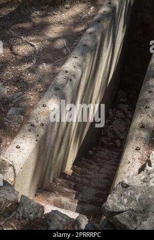 L'ingresso ad un bunker militare nascosto segreto. Rifugio bomba abbandonato. Sfondo Foto Stock