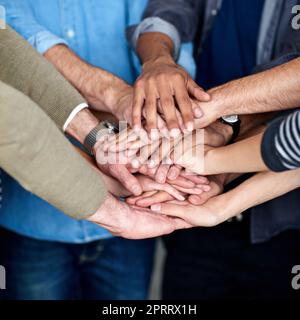 Tutto insieme. Vista ritagliata di un gruppo multietnico che mette le mani insieme nell'unità. Foto Stock