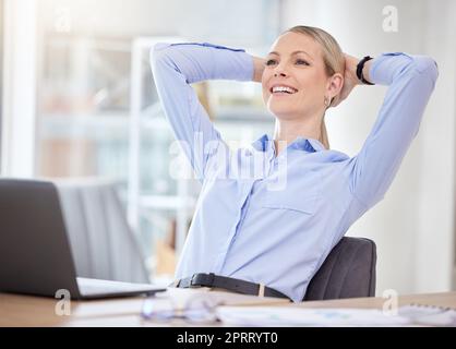 Una donna d'affari felice e soddisfatta, con un compito, un obiettivo di lavoro o la conclusione di un accordo di successo. Comodo, mani dietro la testa e relax con l'imprenditore che si diverte a riposare in ufficio Foto Stock