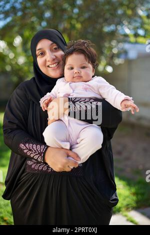 Una manciata di gioia: Una madre musulmana e la sua bambina. Foto Stock