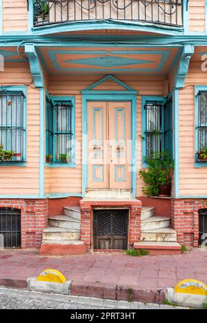 Vecchio e colorato edificio residenziale in legno con porta, finestre in ferro battuto e piante da scalatore verdi, Istanbul, Turchia Foto Stock