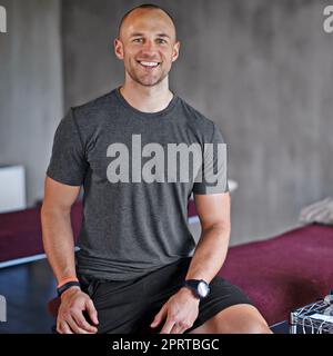 Condurre i miei clienti ad una vita più sana. Un addestratore che siede con l'apparecchiatura in una palestra. Foto Stock