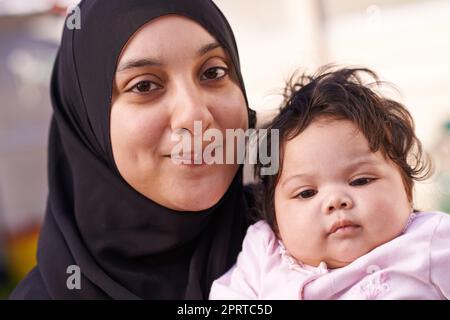 Prende dopo il suo papà. Una madre musulmana e la sua bambina. Foto Stock