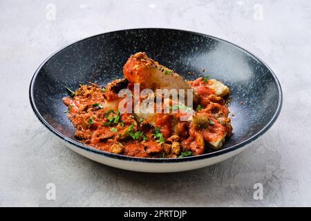 zander arrosto servito con pomodoro al vapore, cipolla e salsa di olive Foto Stock