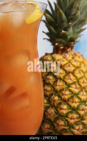 Drink tropicale Hurricane sulla spiaggia con cocktail fresco di arancia e ananas con succo di frutta Foto Stock