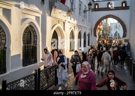 Persone che passeggiando per una strada trafficata nella medina Tetouan al tramonto. Foto Stock