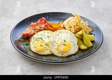 Uova fritte con pancetta e cavolo sottaceto con cetriolo Foto Stock