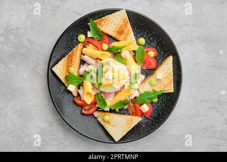 Vista dall'alto di pezzi di pane tostato, prosciutto, uova sode, cheddar e pomodoro Foto Stock