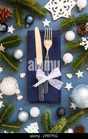 Tavolo di Natale blu e bianco con decorazioni e vista dall'alto dei rami di abete Foto Stock