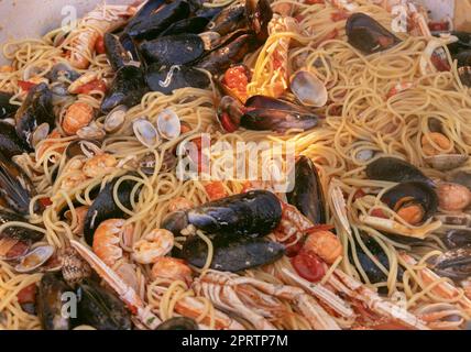 Spaghetti italiani allo scoglio, primi piani di pasta con frutti di mare e pomodori in padella Foto Stock
