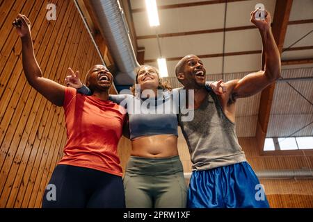 Emozionanti atleti maschili e femminili che allietano insieme al campo sportivo Foto Stock