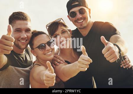 Gli amici fanno i bei momenti ancora più belli. Ritratto di un felice gruppo di amici in posa insieme fuori Foto Stock