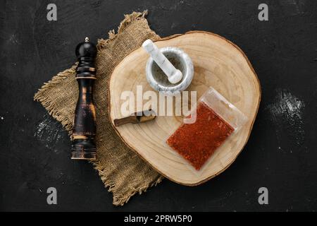 Sezione trasversale in legno con paprika in confezione di plastica, Malta e mulino Foto Stock