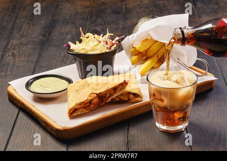 Snack fast food e un bicchiere di cola su un tavolo Foto Stock