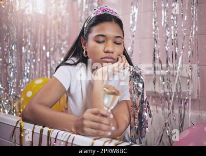 Ragazza di compleanno, triste e champagne mentre si sentiva annoiata, sconvolta e delusa mentre sedeva da sola nella vasca da bagno solitaria e depressa. Donna infelice, noiosa e abbandonata durante la celebrazione della quarantena Foto Stock