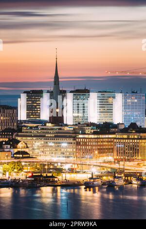 Stoccolma, Svezia. Vista della chiesa di San Clara o di San Klara e delle case in luci crepuscolari. Illuminazione notturna. Foto Stock