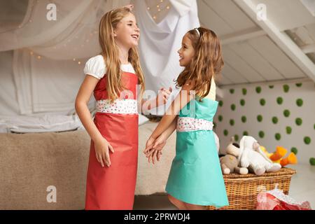 Mi piace quel vestito che indossa. Due bambine che si vestono in modo divertente. Foto Stock