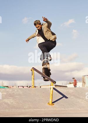 Macinare come un professionista. Uno skateboarder che esegue un trucco su una rotaia. Foto Stock