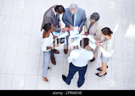 Analizzando i risultati trimestrali. Un gruppo di uomini d'affari diversi che discutono i documenti in una riunione. Foto Stock