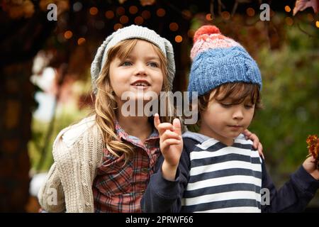 Due simpatici bambini giocano in giardino il giorno d'autunno. Foto Stock