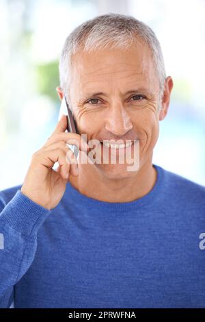 Stare al passo con le notizie di famiglia. Ritratto di un uomo maturo sorridente al telefono. Foto Stock