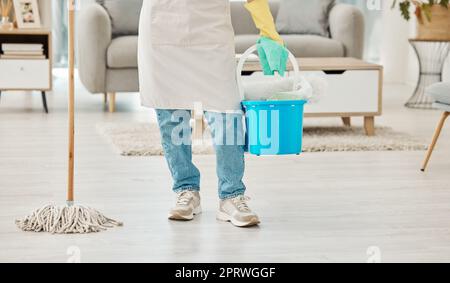 Gambe di donna che pulisce la casa con attrezzature per la casa, mop e secchio per l'igiene del pavimento, polvere e sporco. Ragazza, addetto alle pulizie o lavoratore che effettua il servizio di pulizia degli interni con detergente per la pulizia del soggiorno Foto Stock