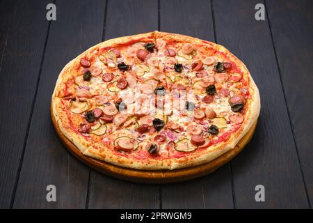 Pizza con vari tipi di salsicce sottili, cetriolo sottaceto, olive e cipolla Foto Stock