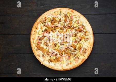 Pizza con pancetta, prosciutto, champignon, cetriolo sottaceto e cipolla Foto Stock