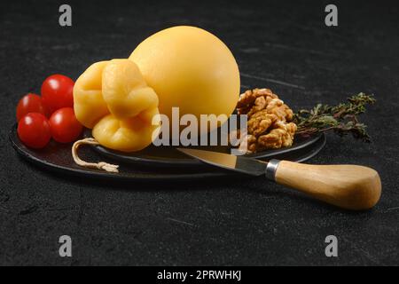 Delizioso formaggio giallo caciocavallo tirato su un piatto Foto Stock