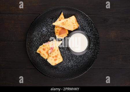 Vista dall'alto di sottili pancake ripieni di prosciutto e formaggio Foto Stock