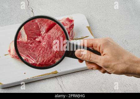 Concetto di carne coltivata. Carne dal bicchiere. Foto Stock