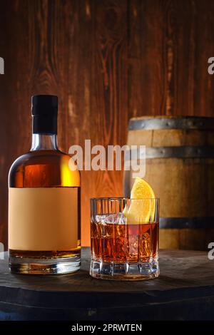 Bottiglia e bicchiere con whisky scotch al malto miscelato su fondo di legno Foto Stock