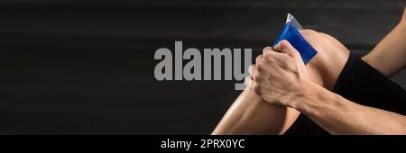 Persona applicando il sacchetto del ghiaccio sul ginocchio Foto Stock