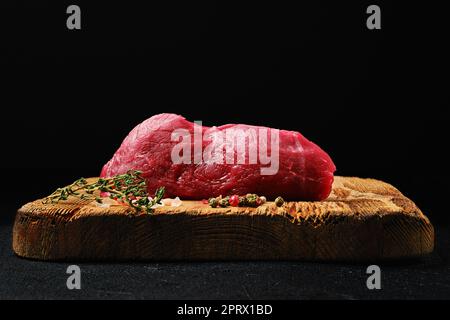 Vista angolare ridotta della lombata di bistecca di manzo cruda sul tagliere Foto Stock