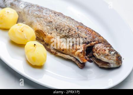 trota alla griglia con patate cotte Foto Stock