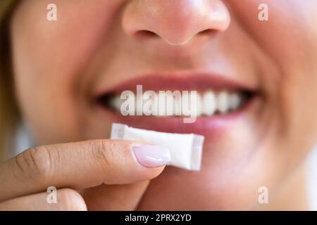 Donna che masticava la nicotina umida tabacco Snus Foto Stock