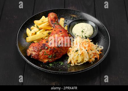 Cosce di pollo al forno con patatine fritte e cavolo sottaceto Foto Stock