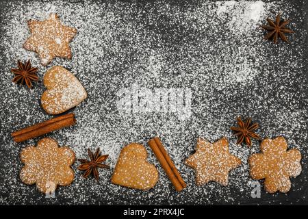 Biscotti al pan di zenzero e spezie su ardesia nera Foto Stock