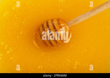 Primo piano cucchiaia in legno nel recipiente per il miele Foto Stock