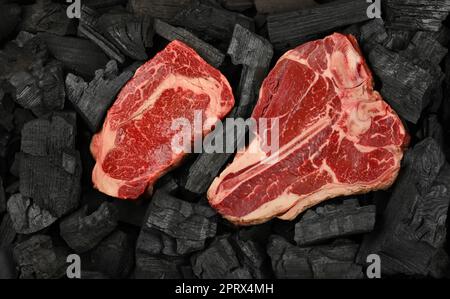 Cucinare bistecche di manzo crude su carbone Foto Stock