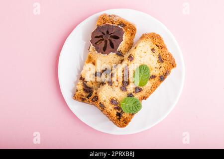 Torta fatta in casa con uvetta e persimmon secco su sfondo rosa pastello. Vista dall'alto, disposizione piatta, primo piano. Foto Stock