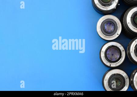 Diversi obiettivi fotografici si trovano su uno sfondo blu brillante. Spazio per il testo Foto Stock