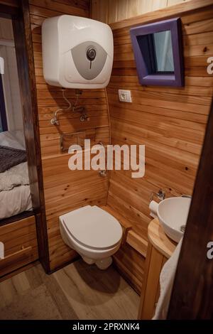 Interno bagno camper con wc, lavabo e pareti in legno. Foto Stock