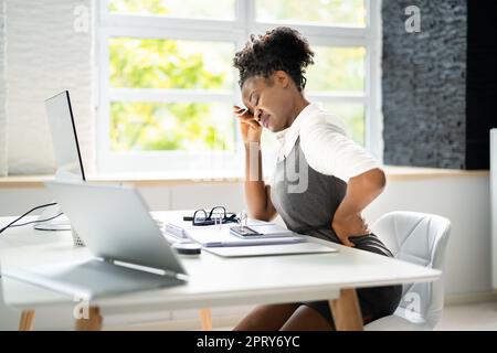 Mal di schiena cattiva postura Donna seduta in ufficio Foto Stock