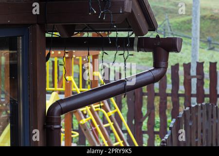 Supporto sistema di drenaggio gocciolatoio sul tetto. Scolare sul tetto della casa. Drenaggio del tetto. Scarico dell'acqua dal tetto. Foto Stock