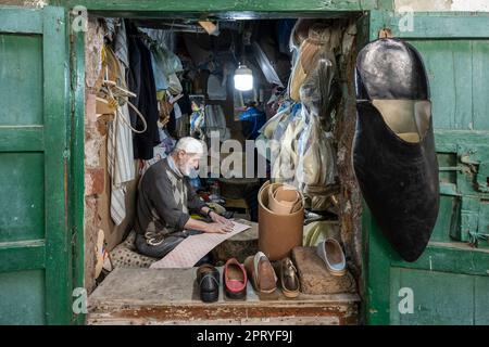 Calzolaio artigiano che taglia sottopiedi in pelle per la fabbricazione di pantofole. Foto Stock