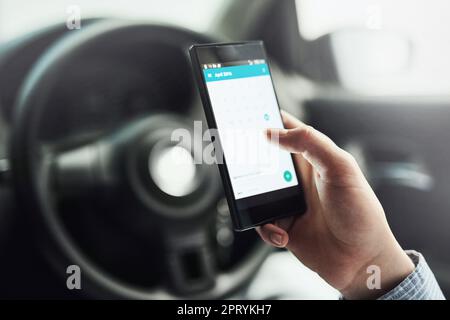 Preparandosi per il giorno durante il viaggio. Primo piano di un conducente utilizzando il cellulare in auto Foto Stock