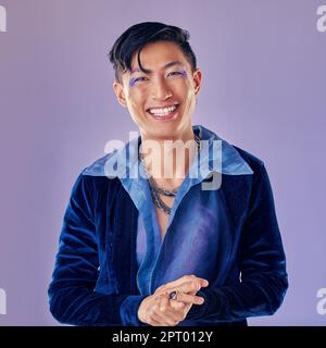 Moda, trucco punk e uomo asiatico in studio isolato su uno sfondo viola. Ritratto di bellezza, lgbtq e cyberpunk modello maschile dal Giappone con cCosmo labbro Foto Stock