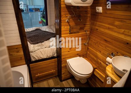 Interno bagno camper con wc, lavabo e pareti in legno. Foto Stock